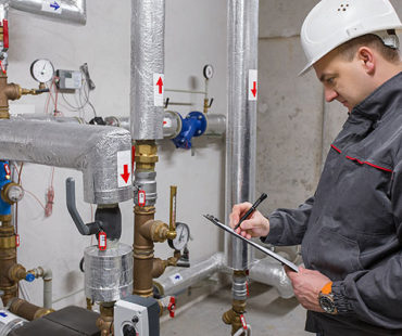 plumber inspecting boiler system